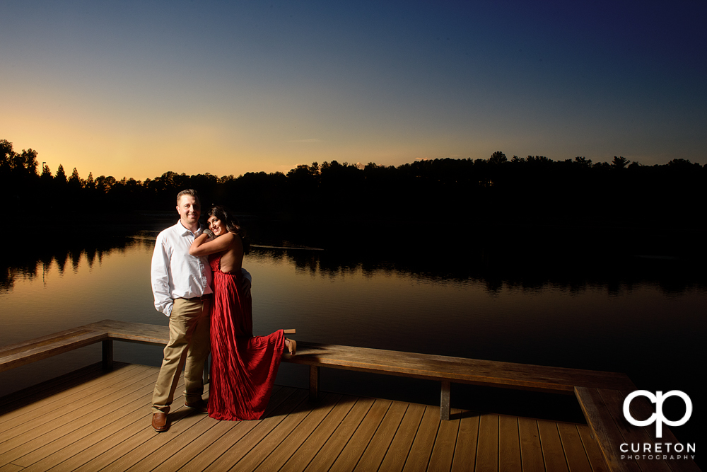 Future bride and groom by the lake at sunset at Furman.