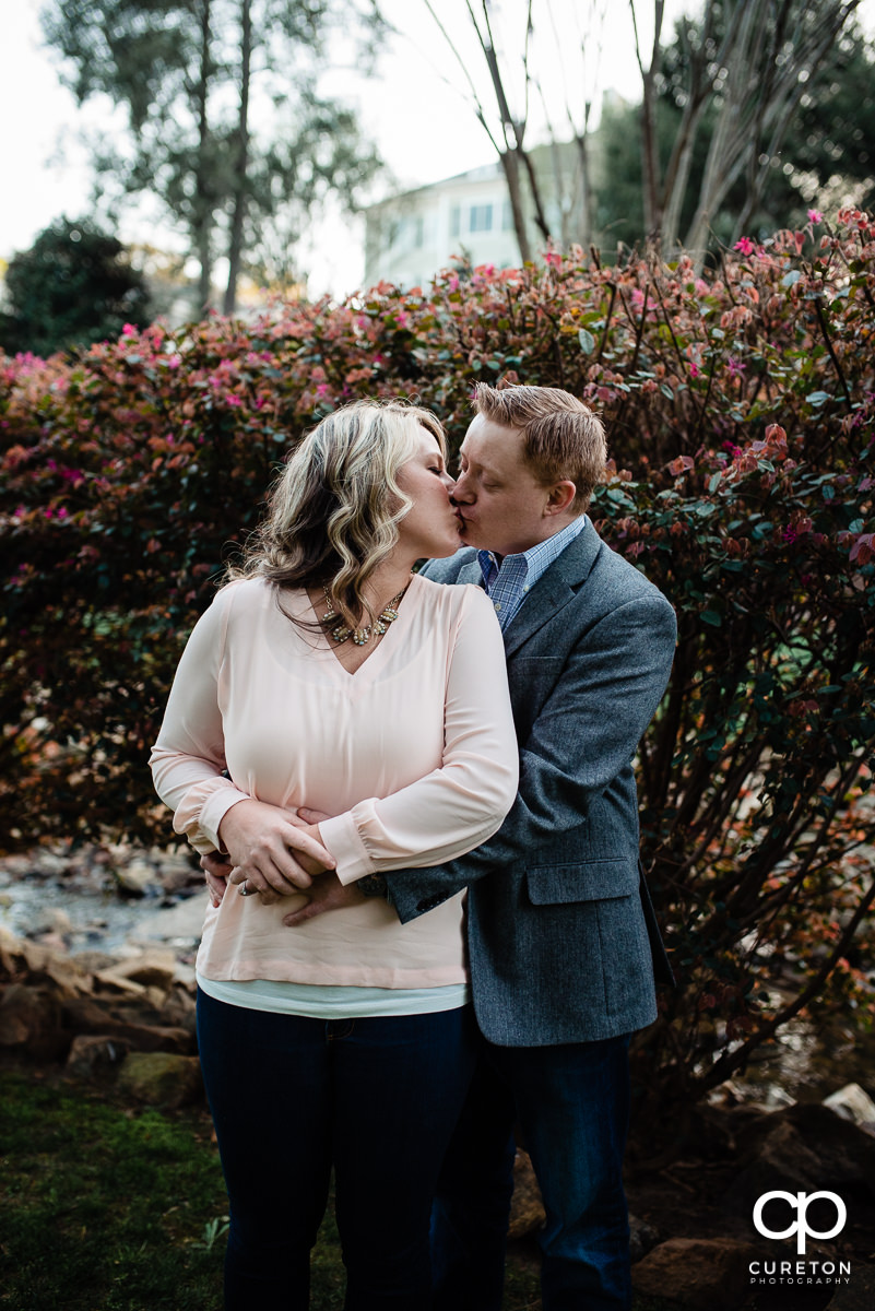 Man kissing his fiancee during their Rock Quarry Garden Engagement Session.