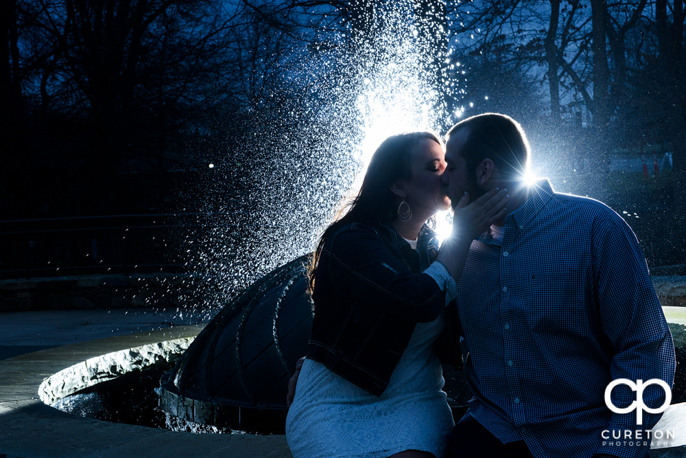 Epic backlit engagement photo of a couple hanging out at falls park in Greenville,SC .