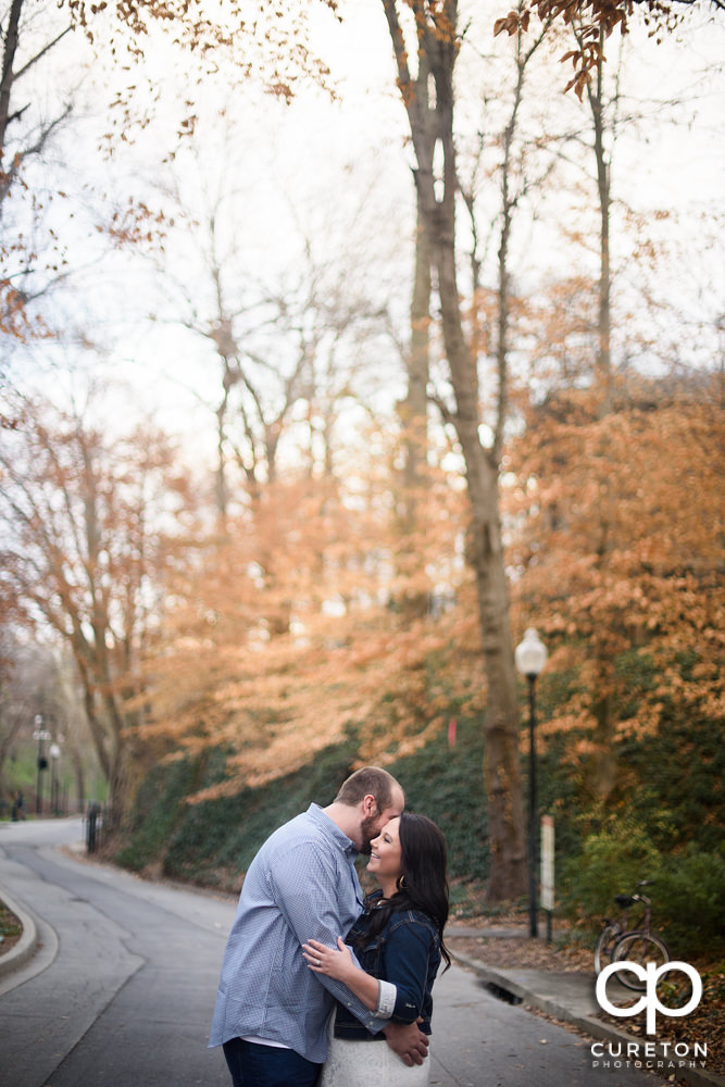 Man whispering into his fiancee's ear during their engagement session.