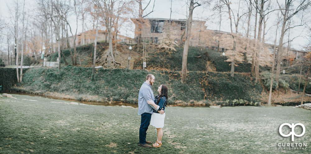 Panoramic view of Falls Park with an engaged couple near the river.