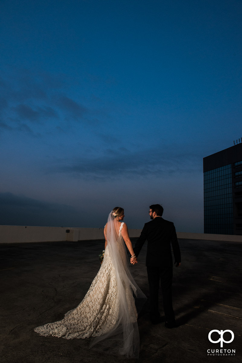 Bride and groom walking on a rooftop in downtown Greenville,SC.