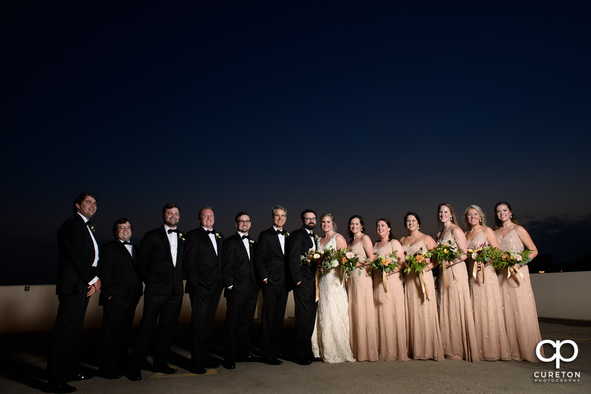 Wedding party on a rooftop in Greenville at dusk.