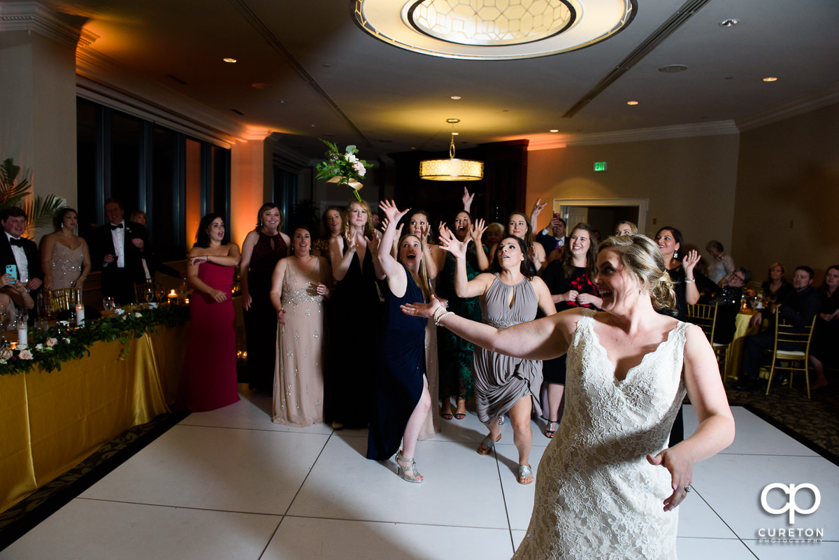 Woman scrambling to catch the bouquet at the wedding reception.