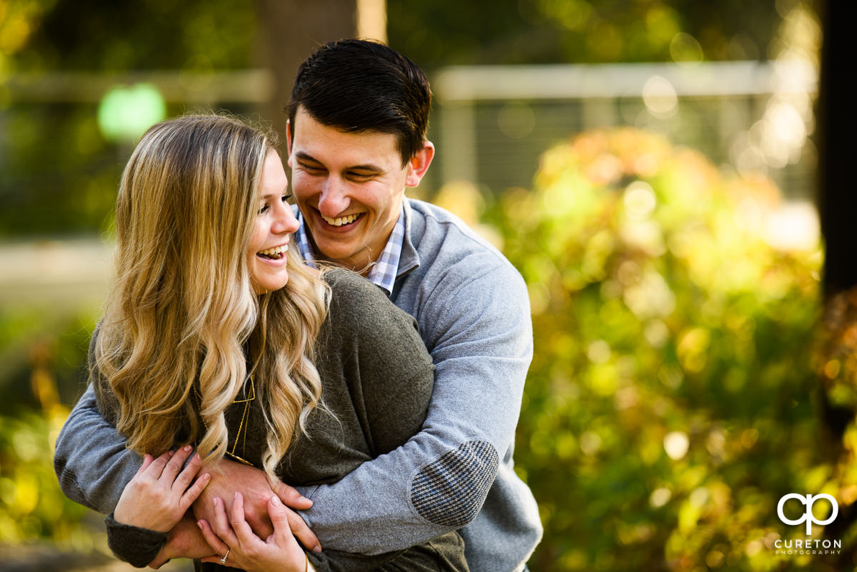 Man hugging his fiancee during a fall engagement session in Greenville SC.