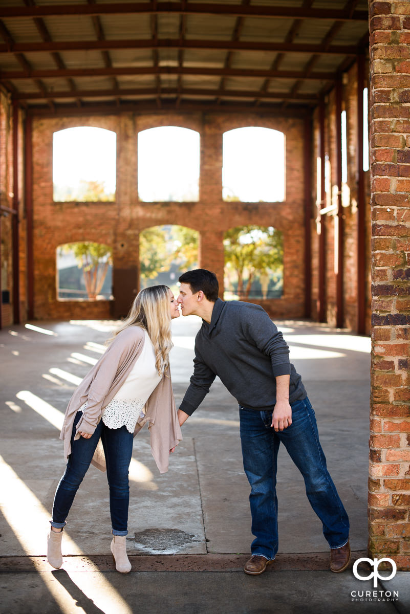 Man and woman kissing at their fall engagement session in Greenville,SC.