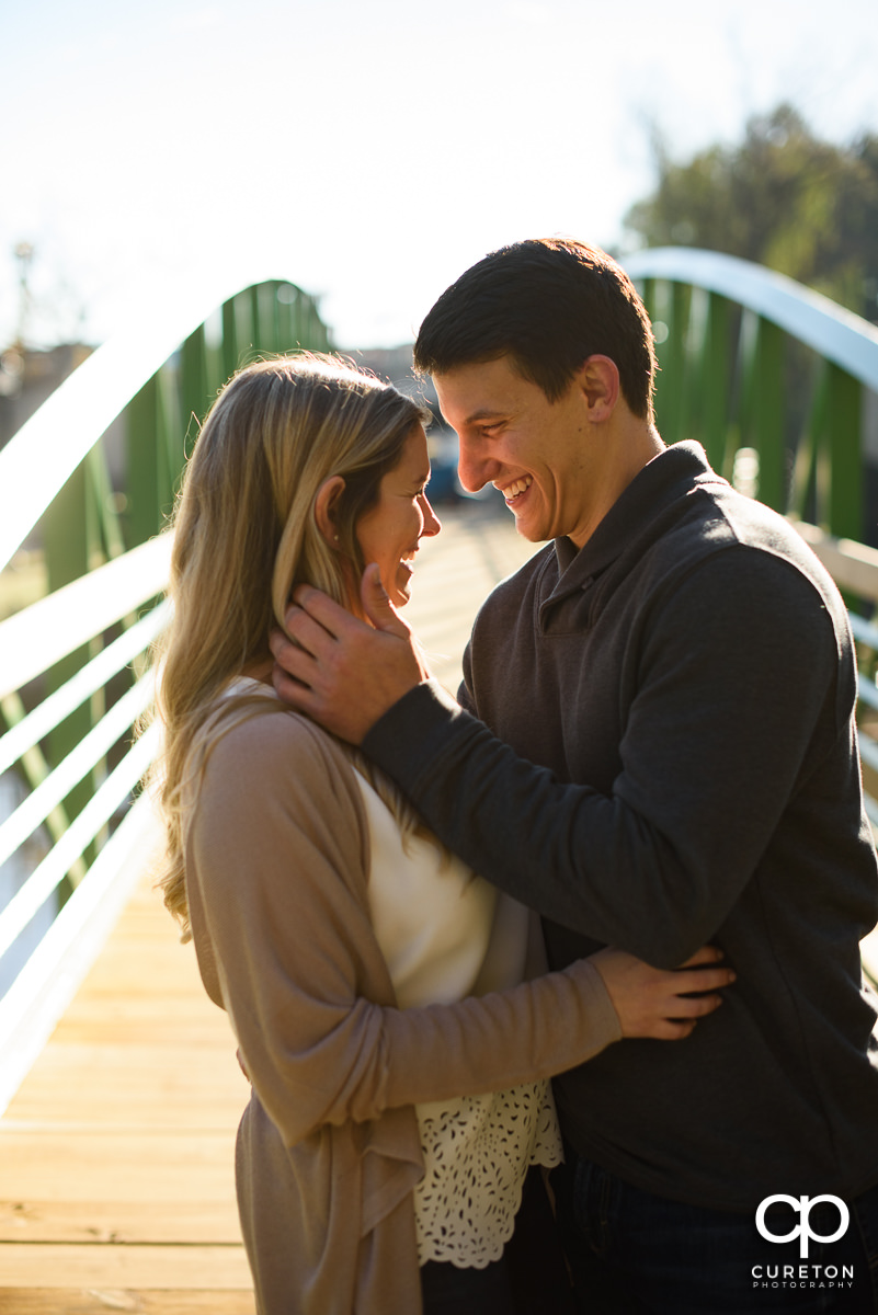 Couple laughing during their fall engagement session in downtown Greenville.