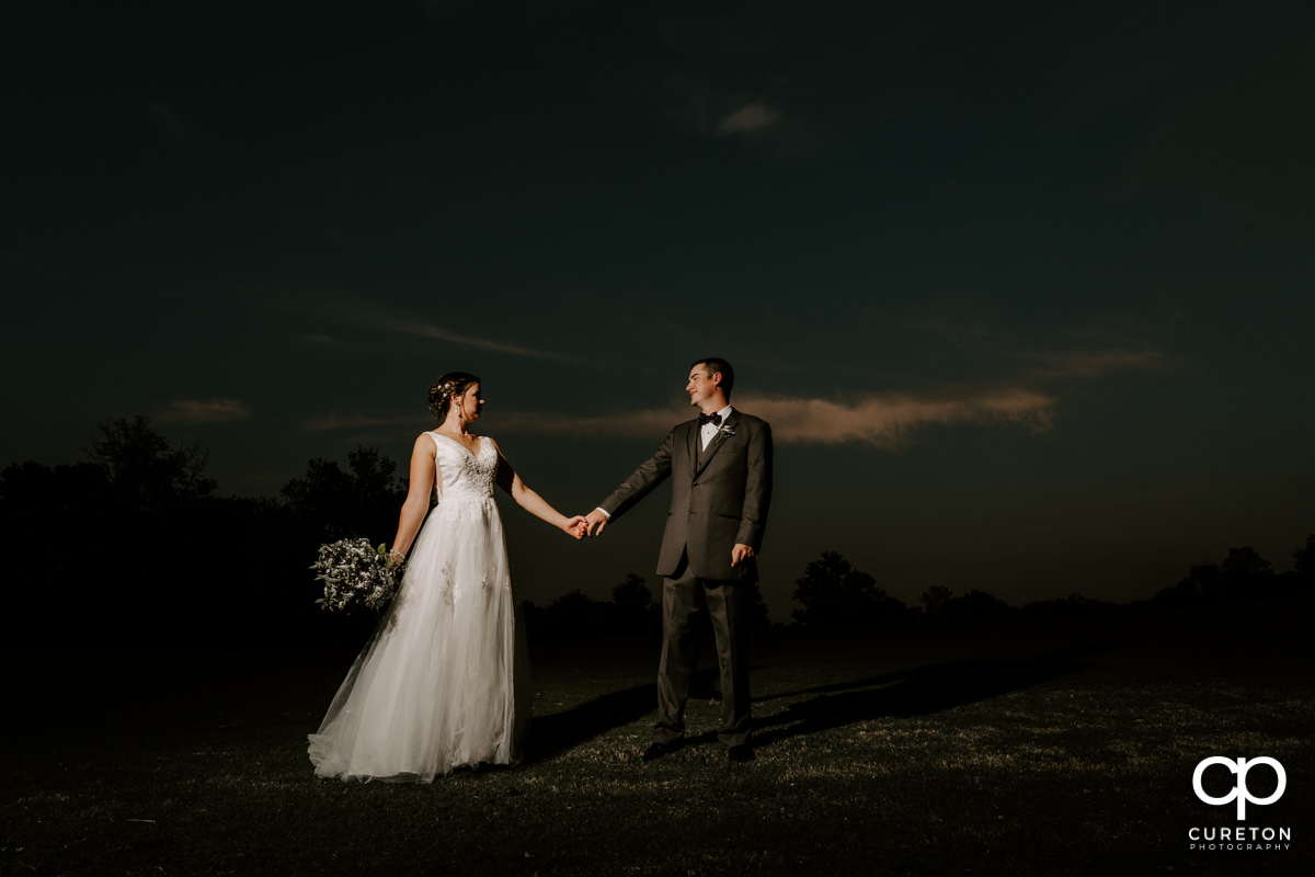 Married couple walking at sunset after their Holly Tree Country Club wedding.