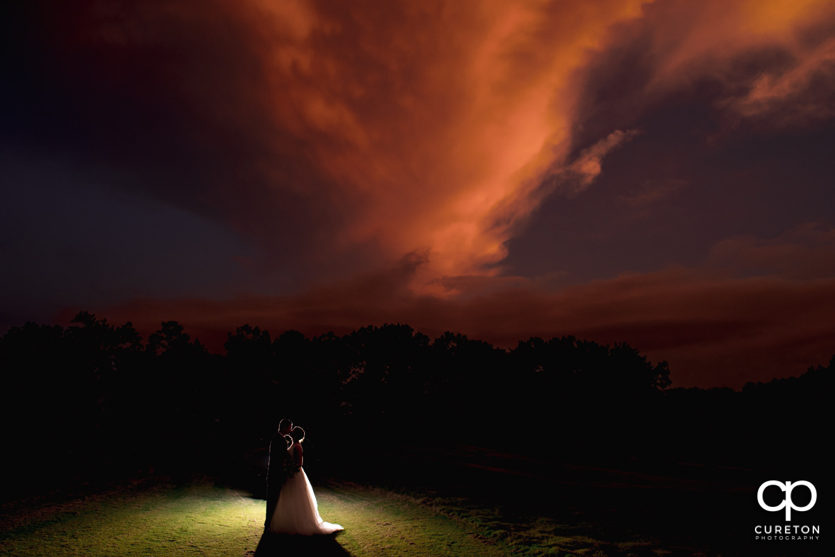 Bride and groom dancing underneath a pink sunset at Holly Tree Country Club in Simpsonville,SC.
