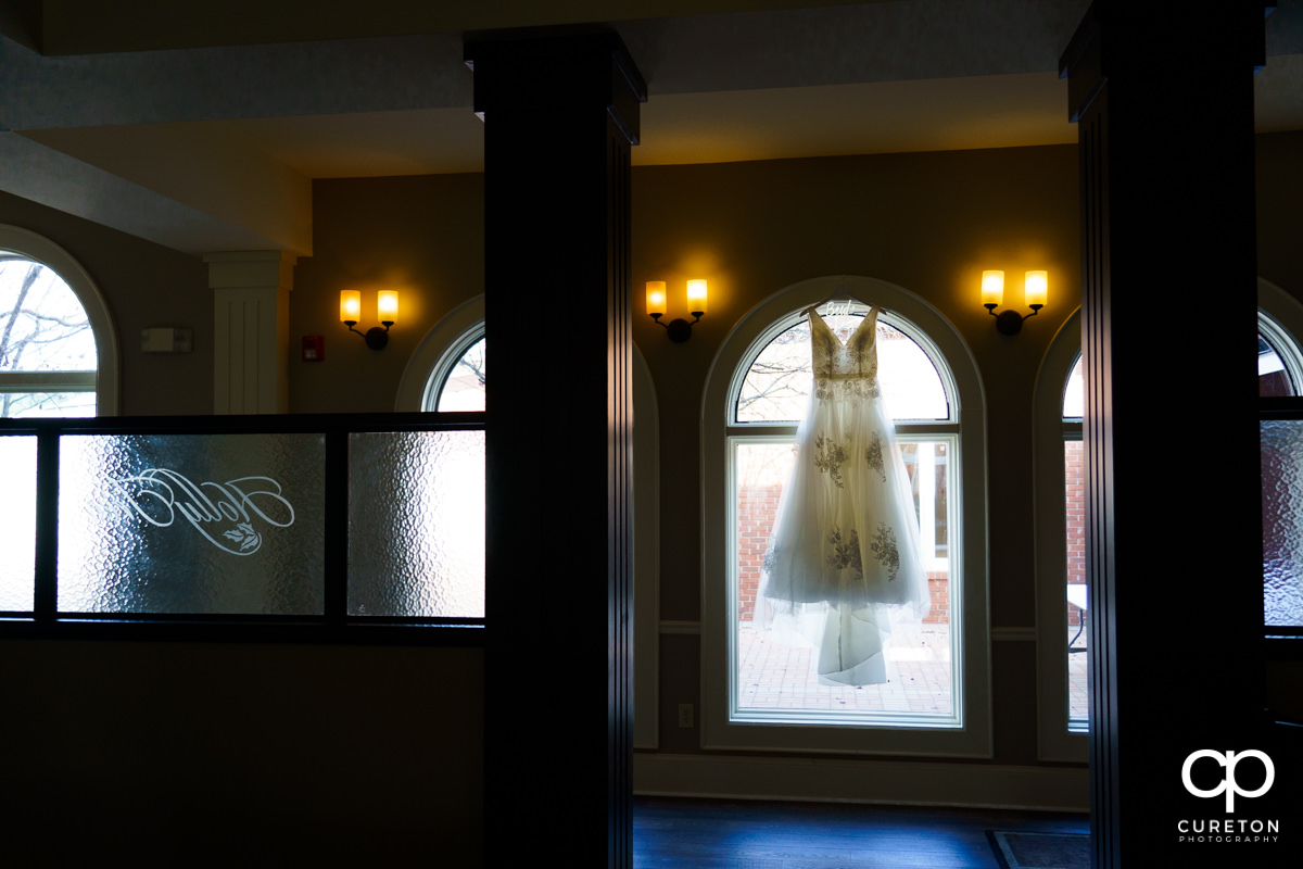 Bridal dress hanging in a window at Holly Tree Country Club.
