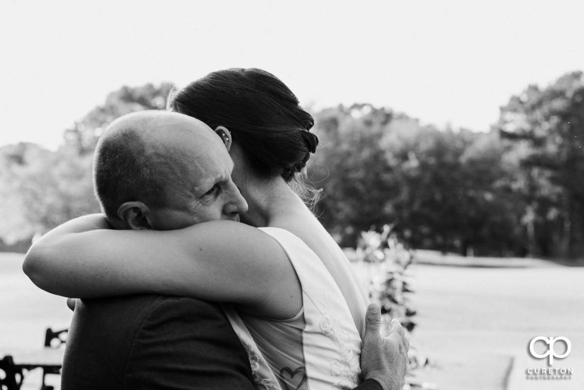 Bride hugging her dad after they have an emotional first look before the wedding ceremony.