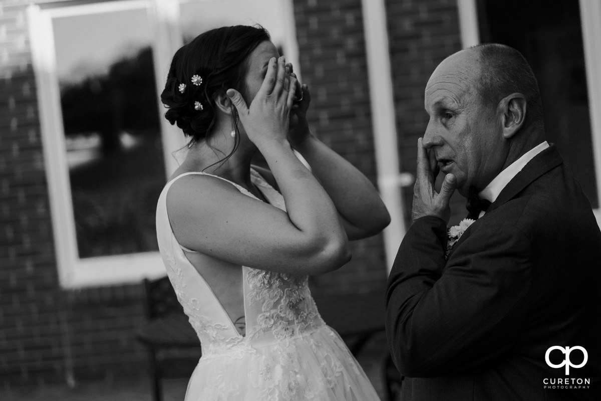 Bride and her father getting emotional.