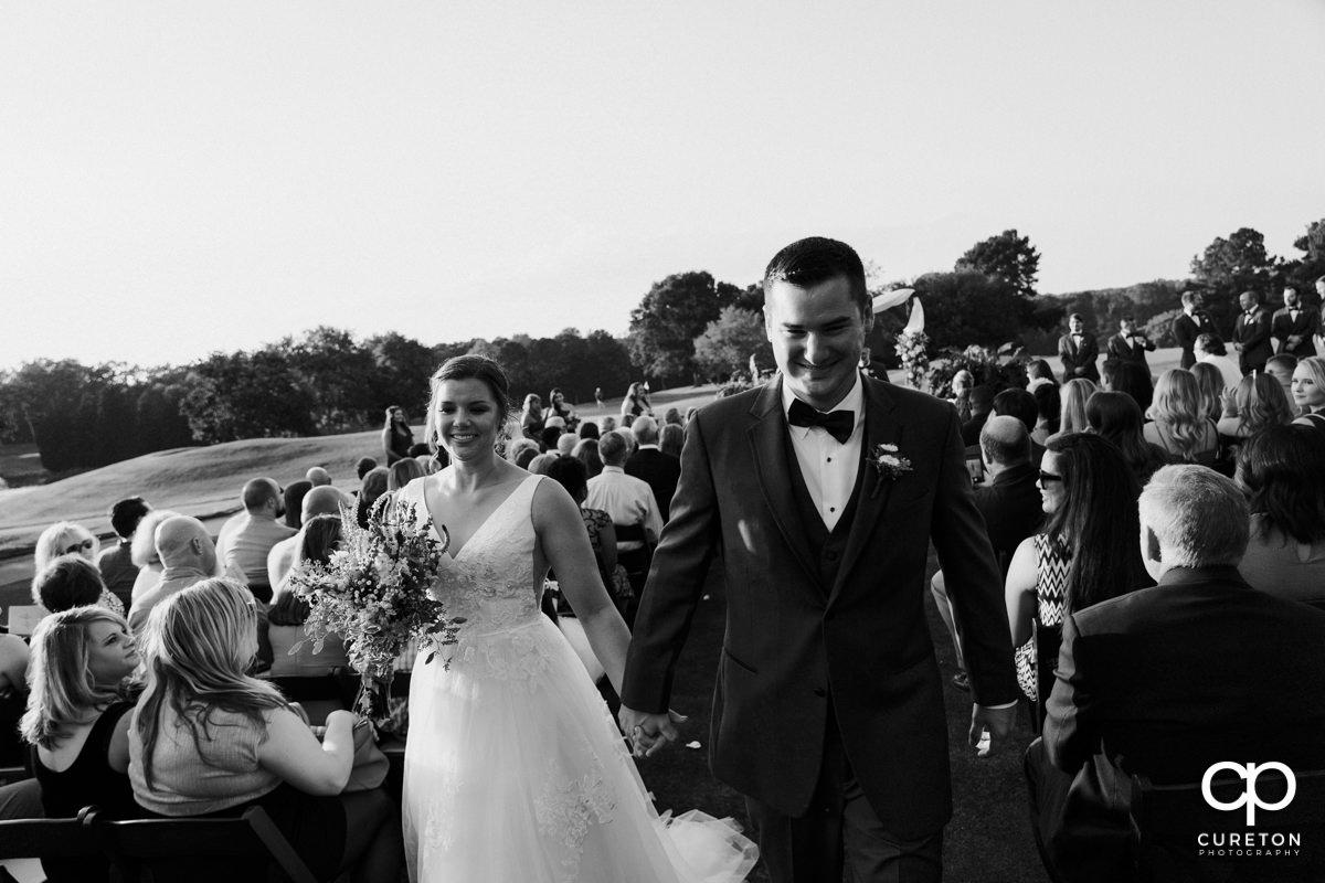 Bride and groom walking back down the aisle at he end of the wedding ceremony.