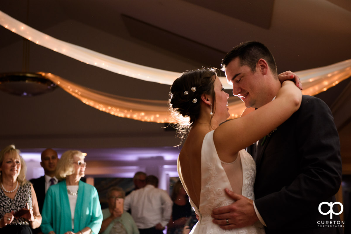 Groom smiling at his bride during the first dance at their Holly Tree Country Club wedding reception.