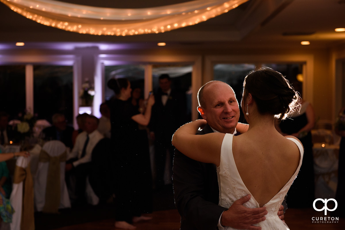 Bride's father dancing with his daughter during her wedding reception.