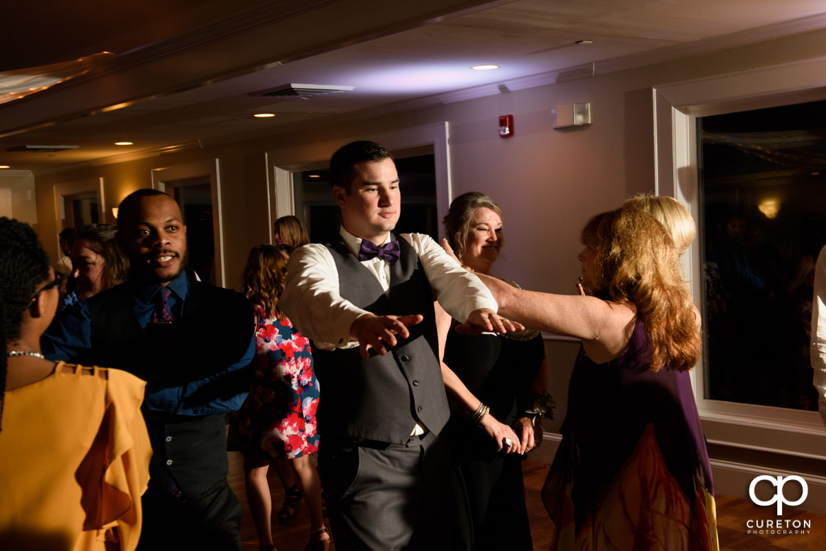 Wedding guests dancing to the sounds of the Party Machine dj at a wedding reception at Holly Tree Country Club.