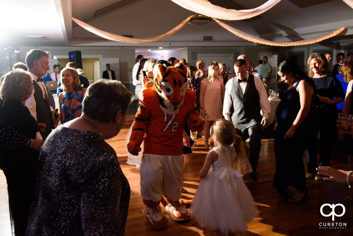 Clemson Tiger dancing with a child at a wedding reception.