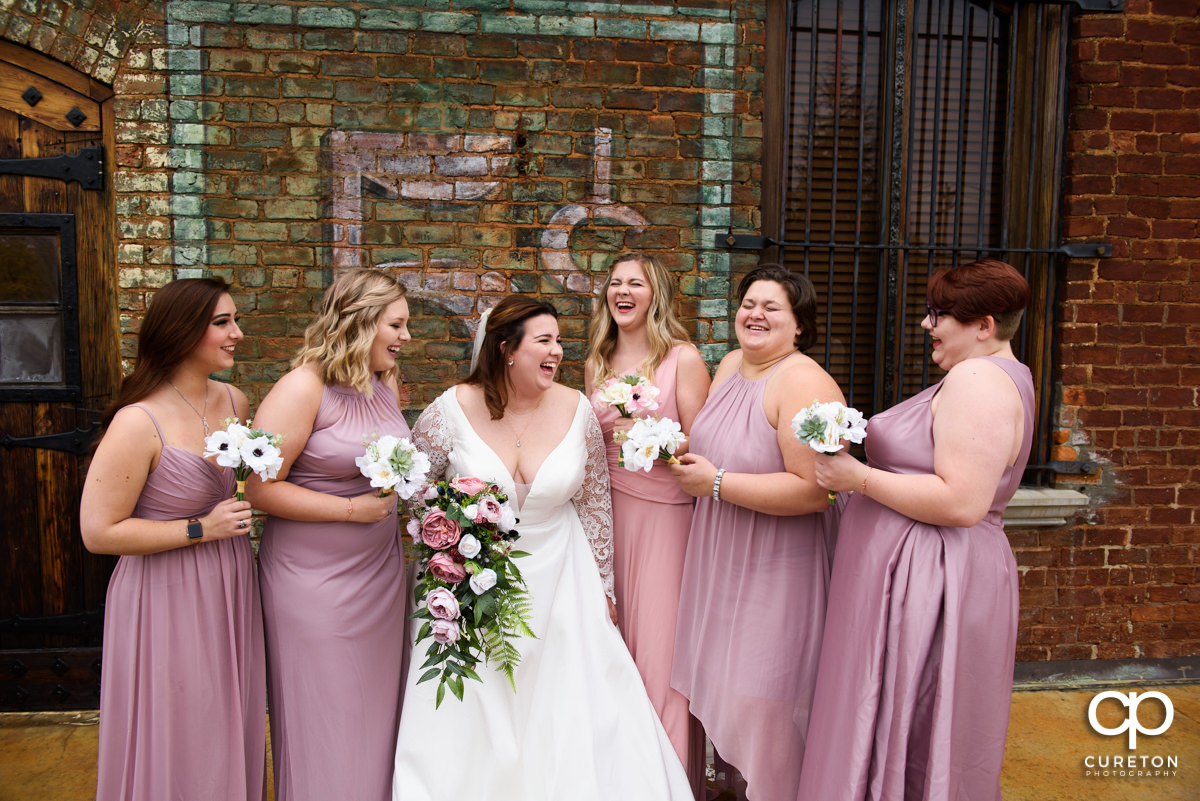 Bride laughing with her bridesmaids before the ceremony.