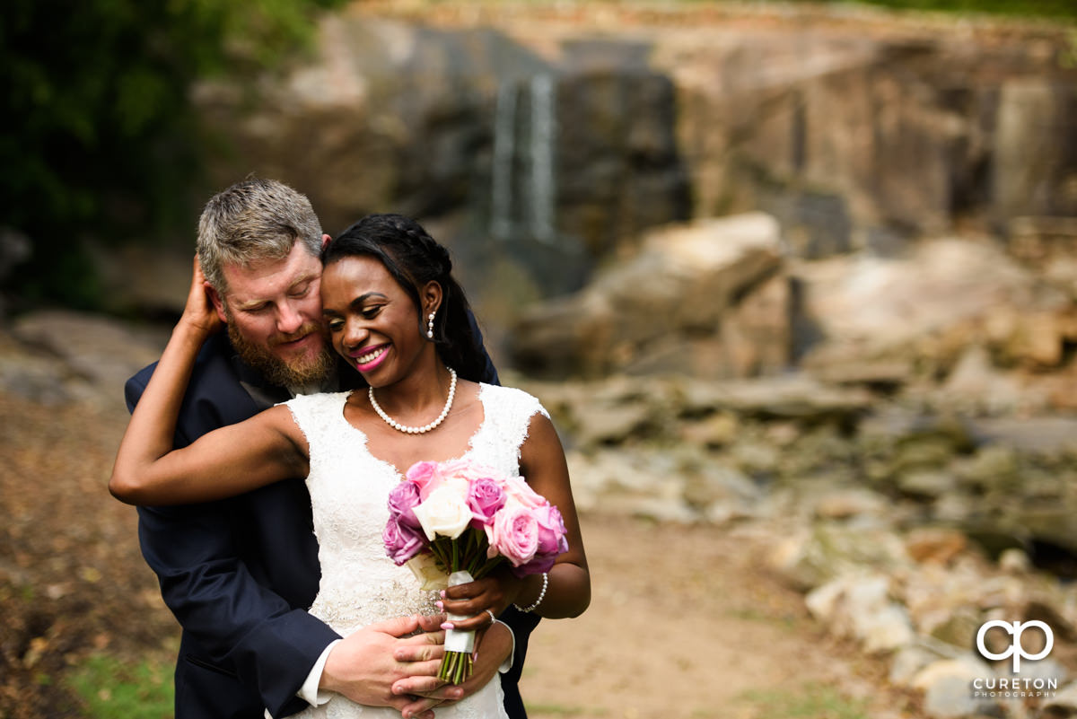 Bride and groom snuggling after a first look at the Rock Quarry Garden..