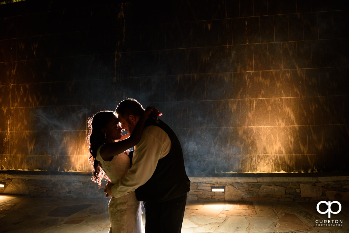 Bride and groom in front of the water wall in downtown Greenville.