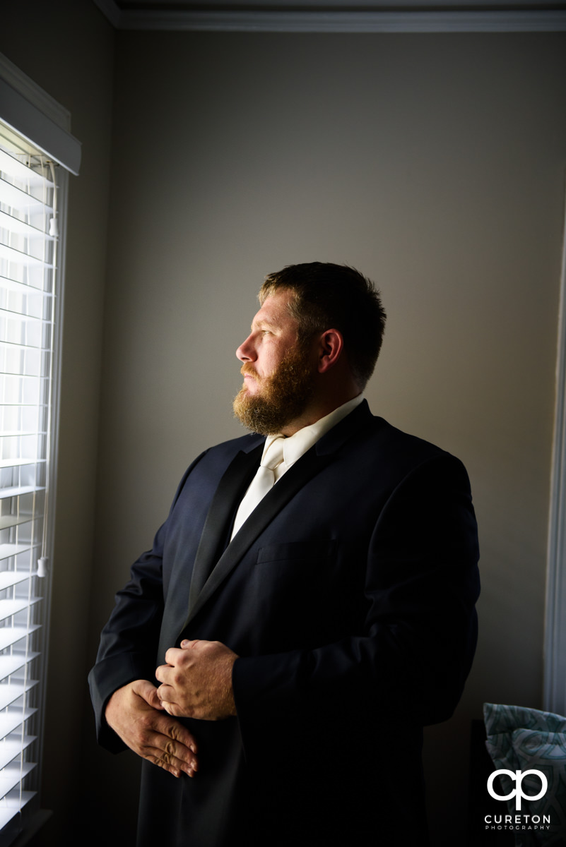 Groom putting on his suit before the wedding.