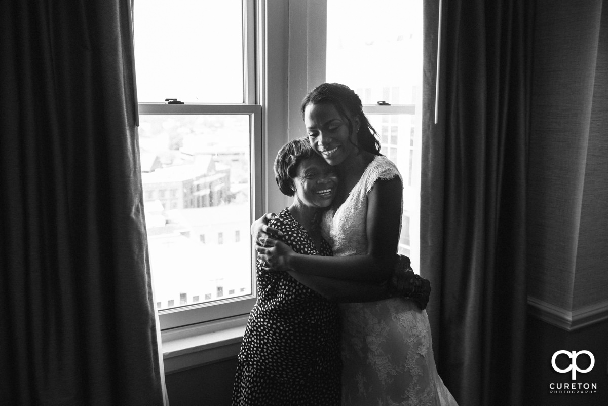 Bride and her mom hugging.