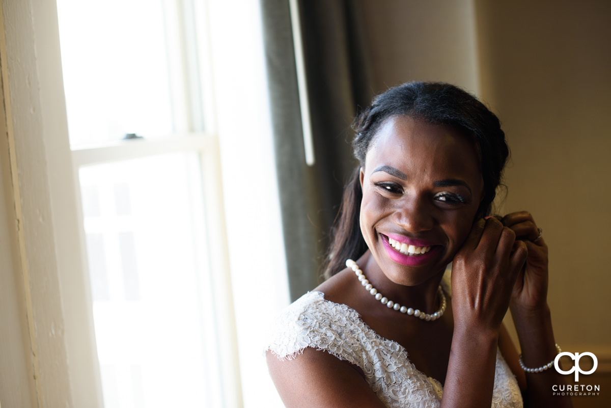 Bride putting on her earrings.