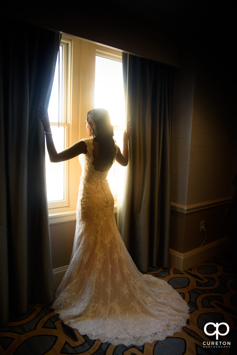 Bride standing in the window light.