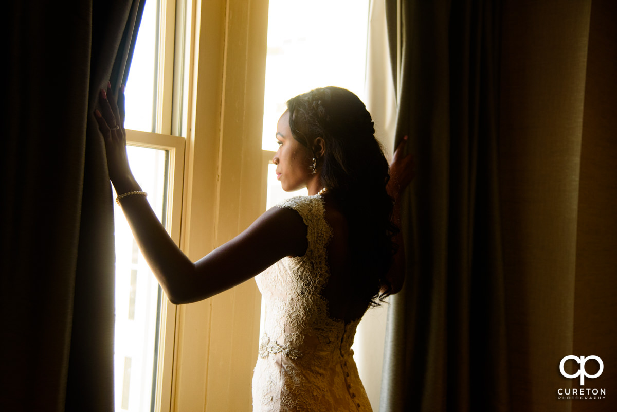 Bride gazing out the window before her wedding.