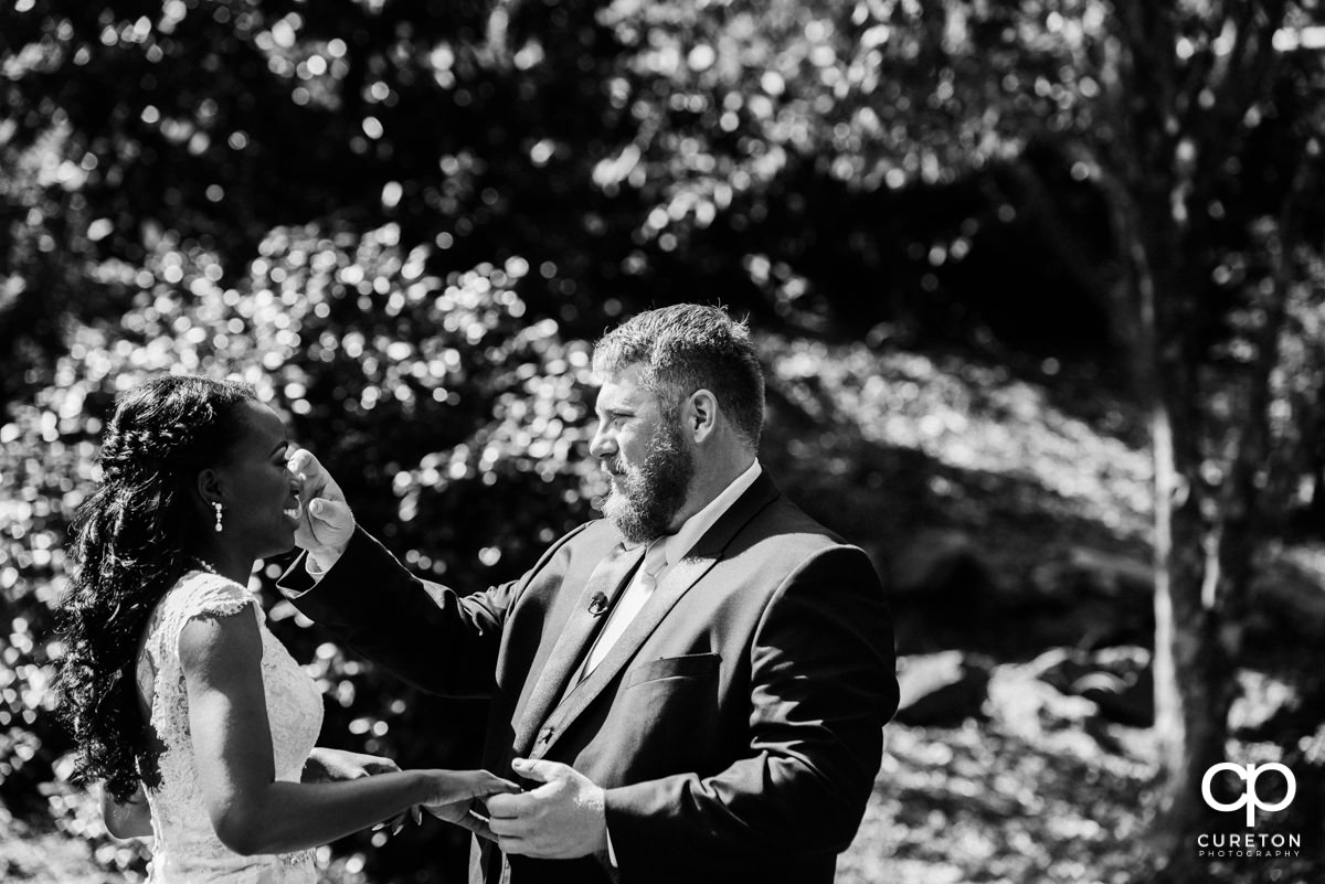 Groom wipes a tear from his bride's eye.