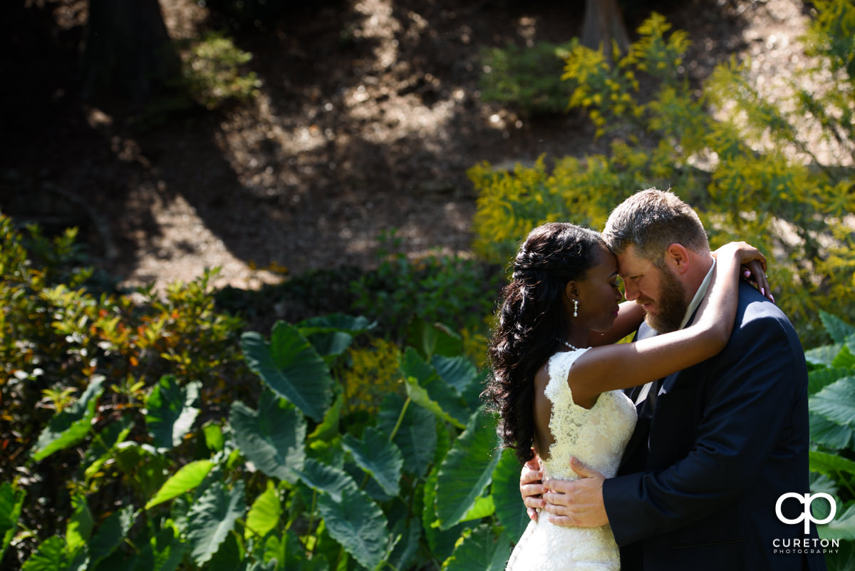 Bride and groom standing forehead to forehead.