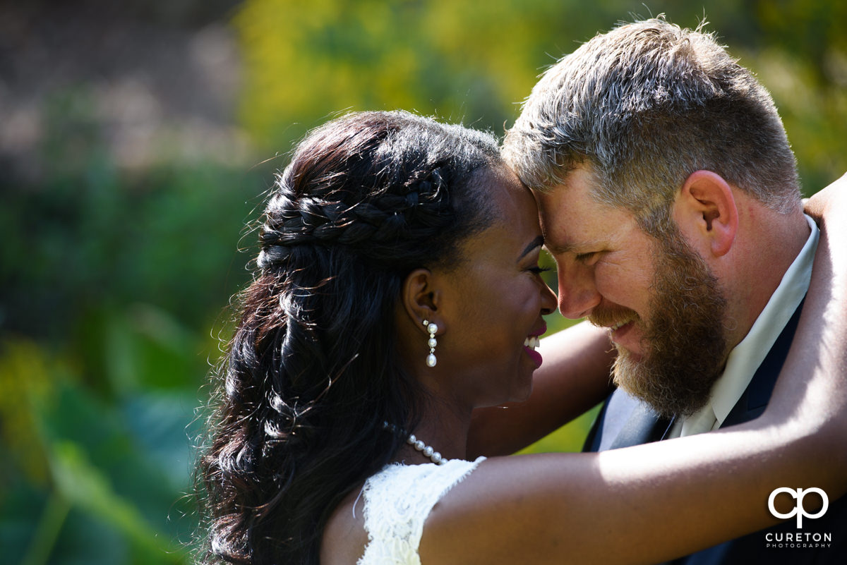 Bride and groom smiling at each other after their first look.