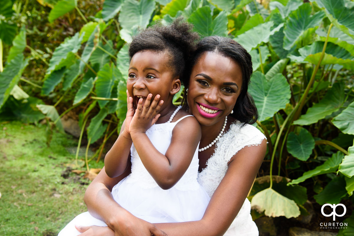 Bride and the flower girl sitting on the ground.