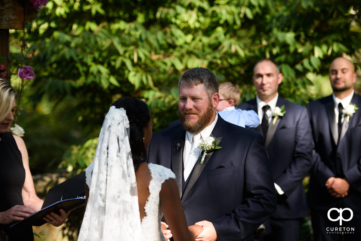 Groom looking at his bride during the wedding ceremony.