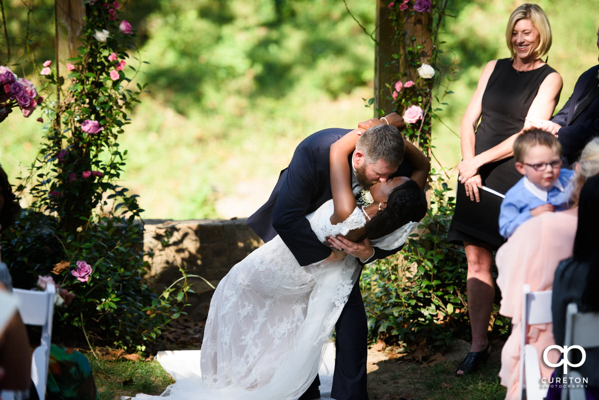 Groom dips his bride during the ceremony.