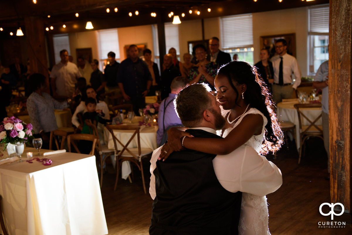 Groom and bride having a first dance at their wedding reception.