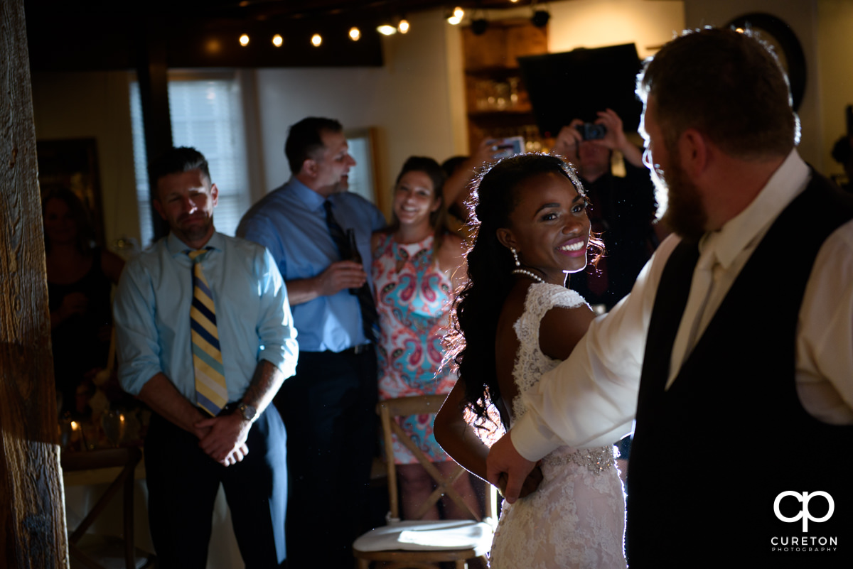 Bride smiling at her groom during their first dance at their Larkin's wedding reception.
