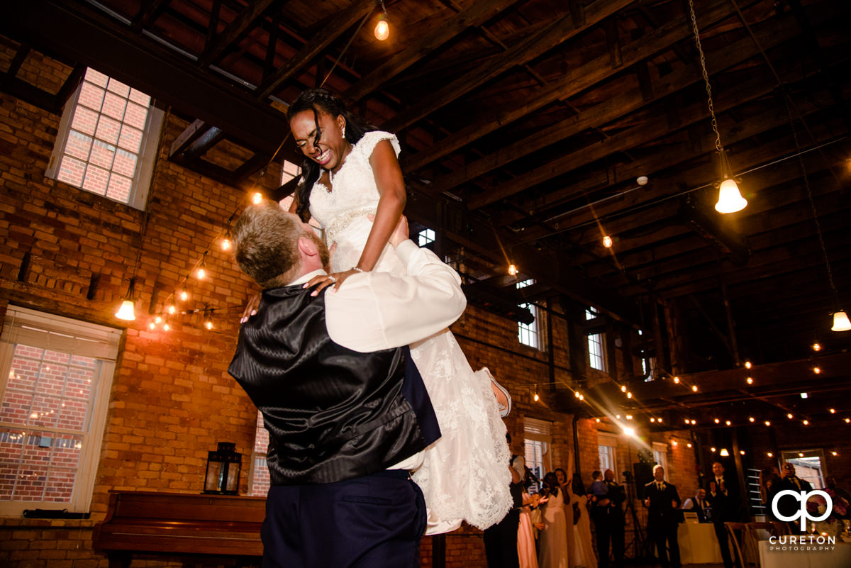 Groom lifting his bride Dirty Dancing style during their first dance at the wedding reception in Greenville.