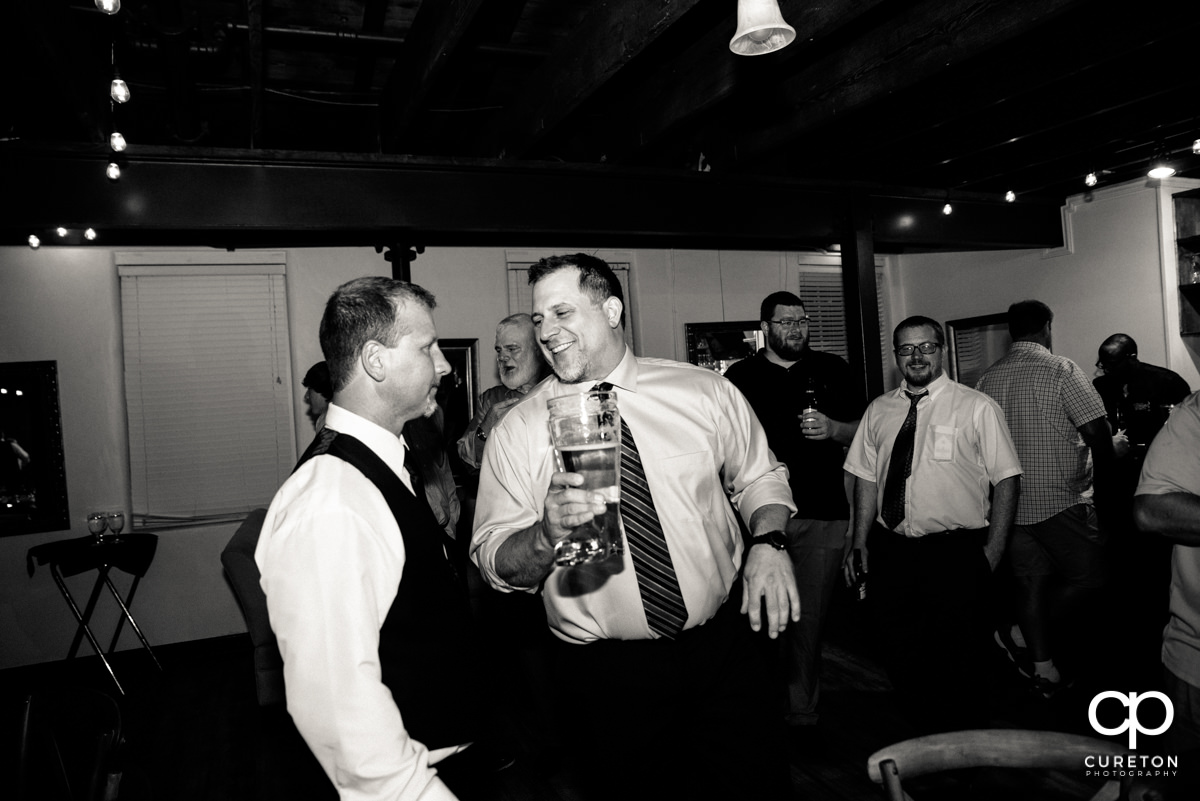 Groomsmen pass around the boot full of beer.