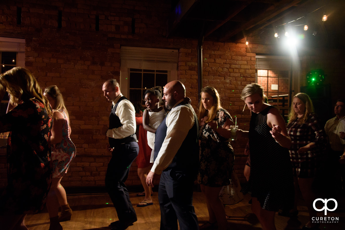 Wedding guests line dancing.