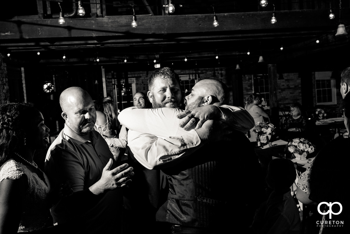 Groomsmen hugging the groom.