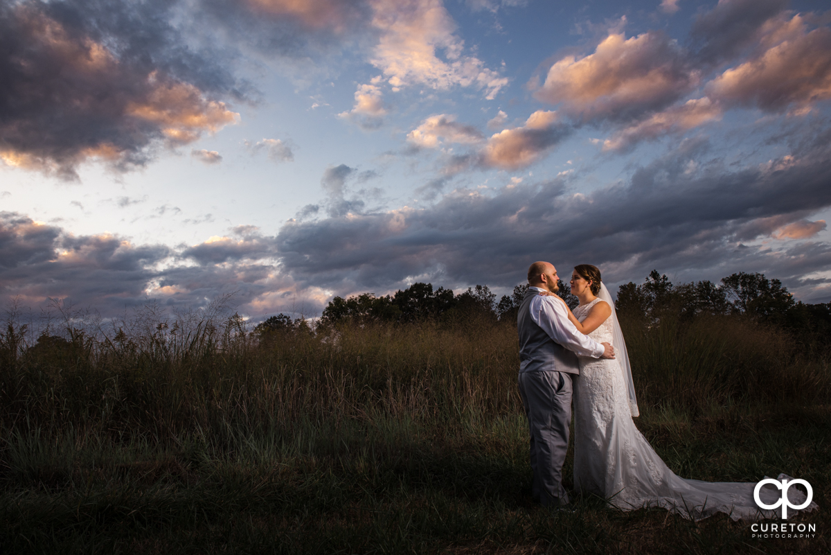 Newly married couple dancing underneath a sunset at Famoda Farm.
