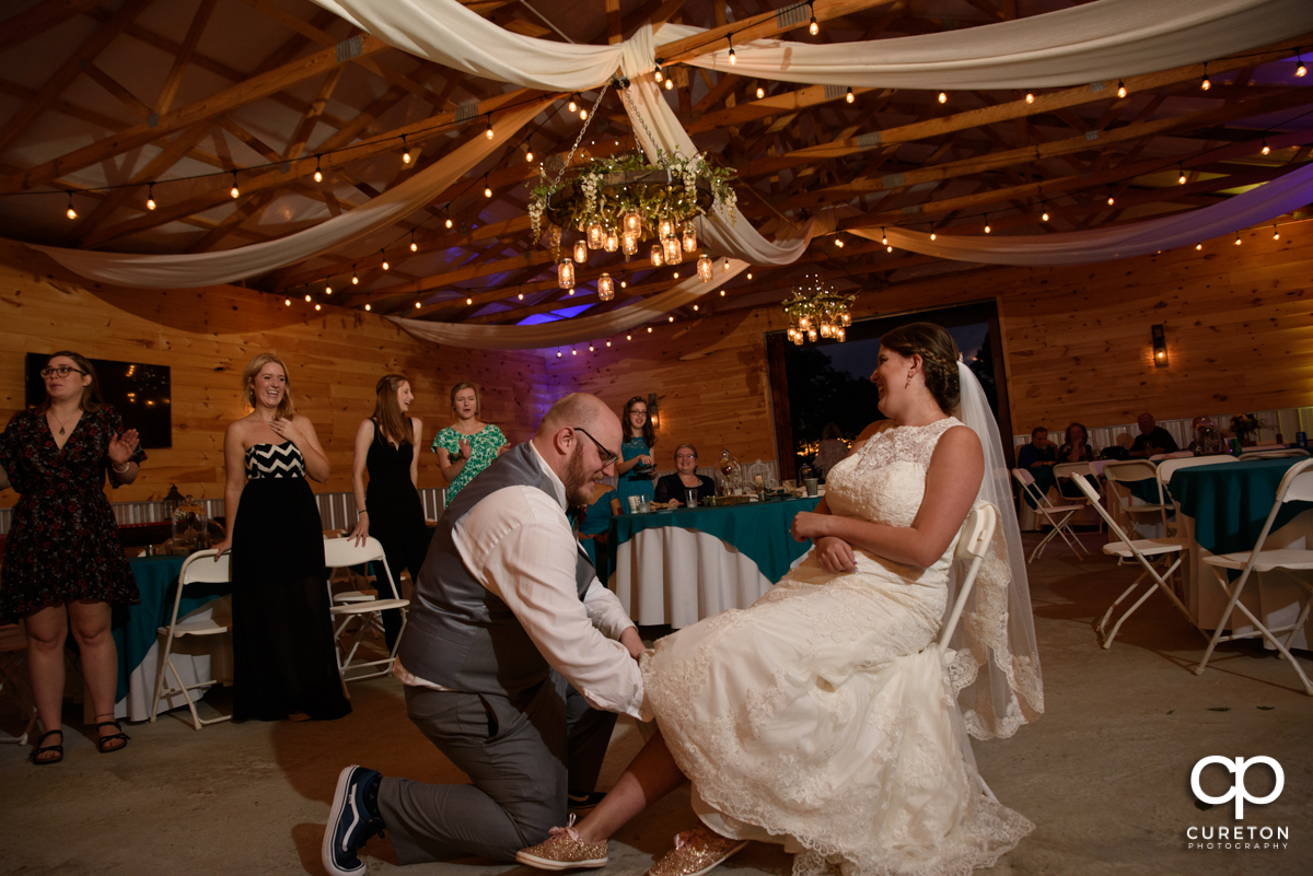 Groom taking the garter off the bride.