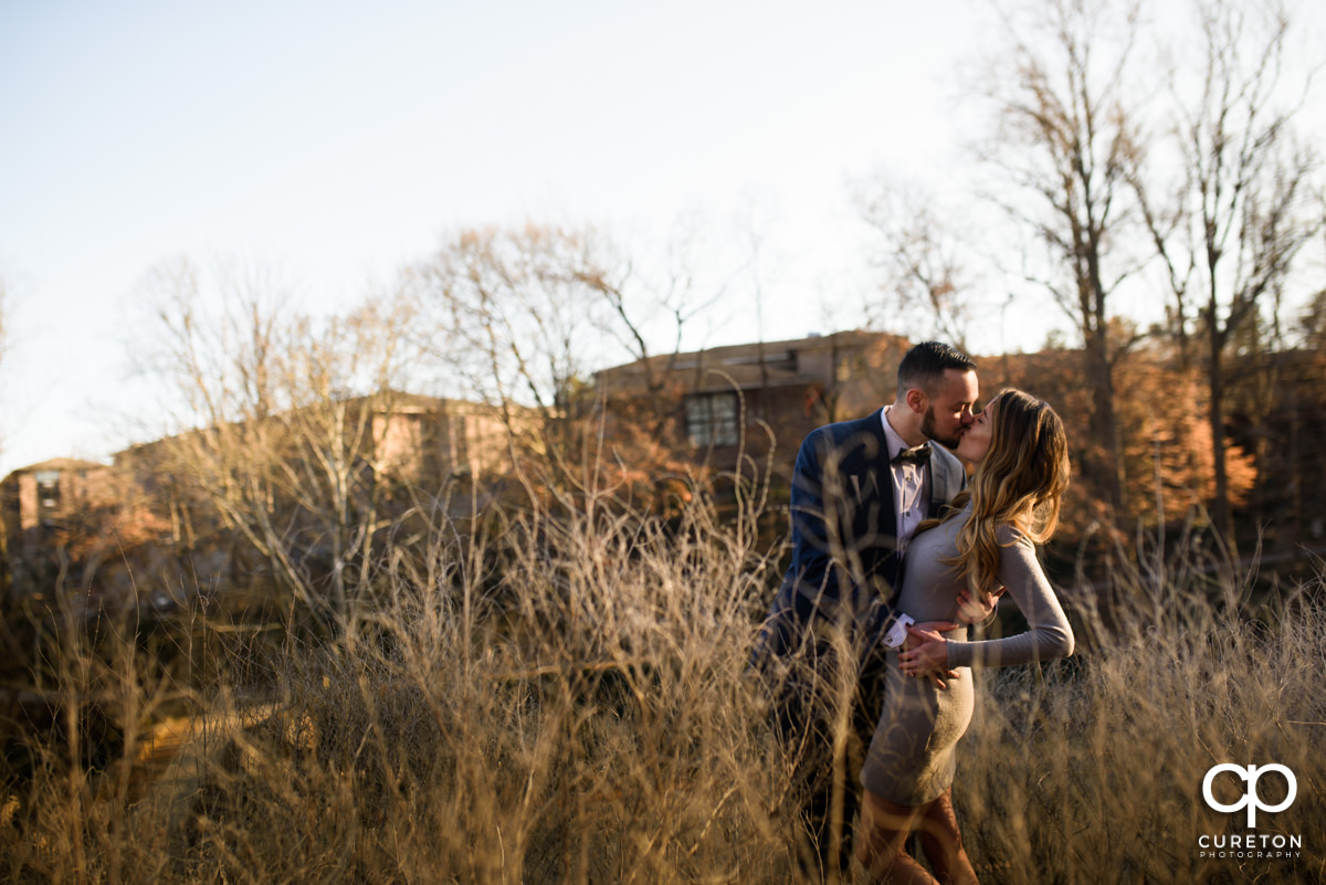 Bride and groom kissing in the park at golden hour in downtown Greenville,SC.