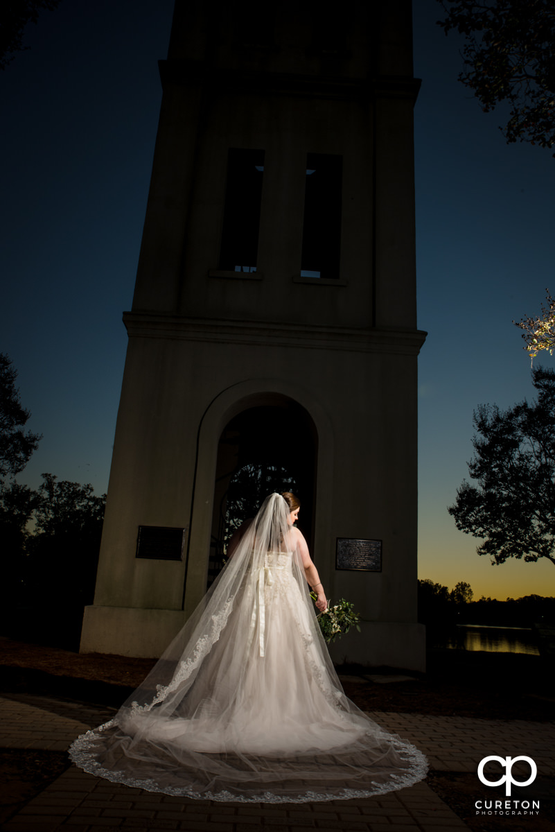 Bride showing off her cathedral veil during a sunset bridal session by the bell tower at Furman University.