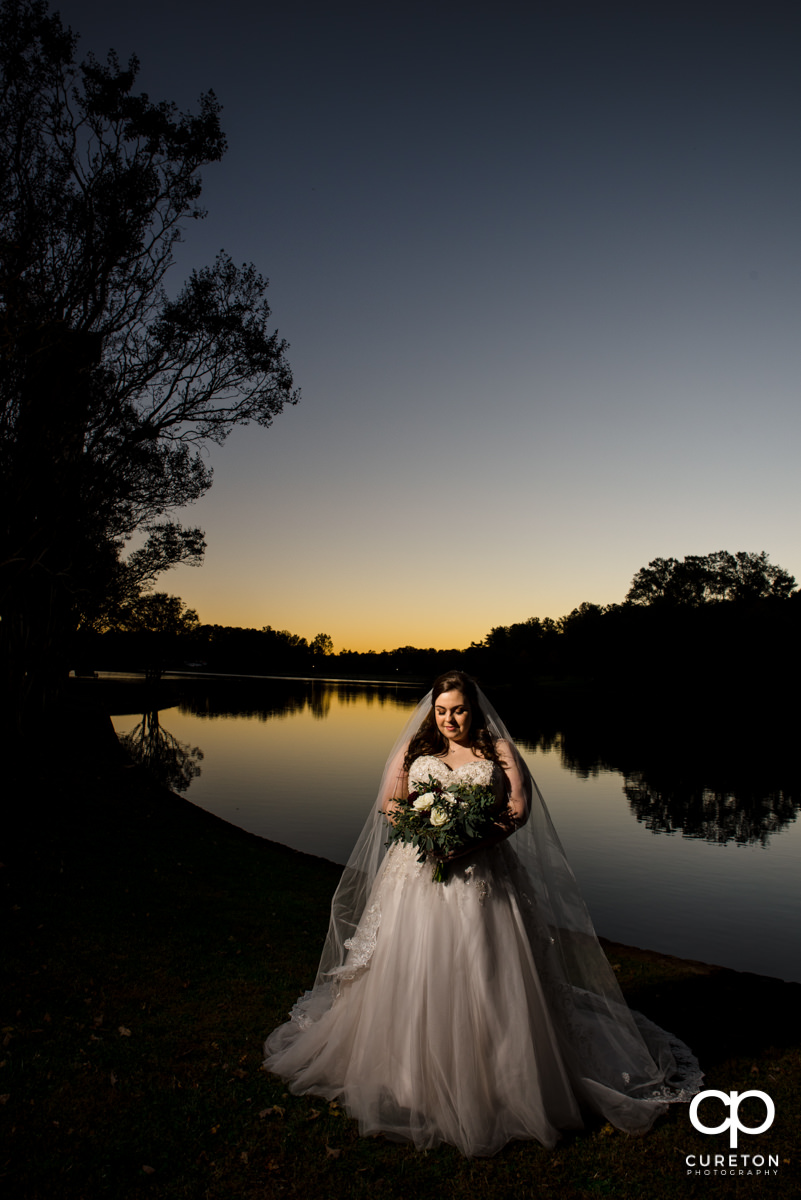 Bride posing by the lake at Furman University during a bridal session.