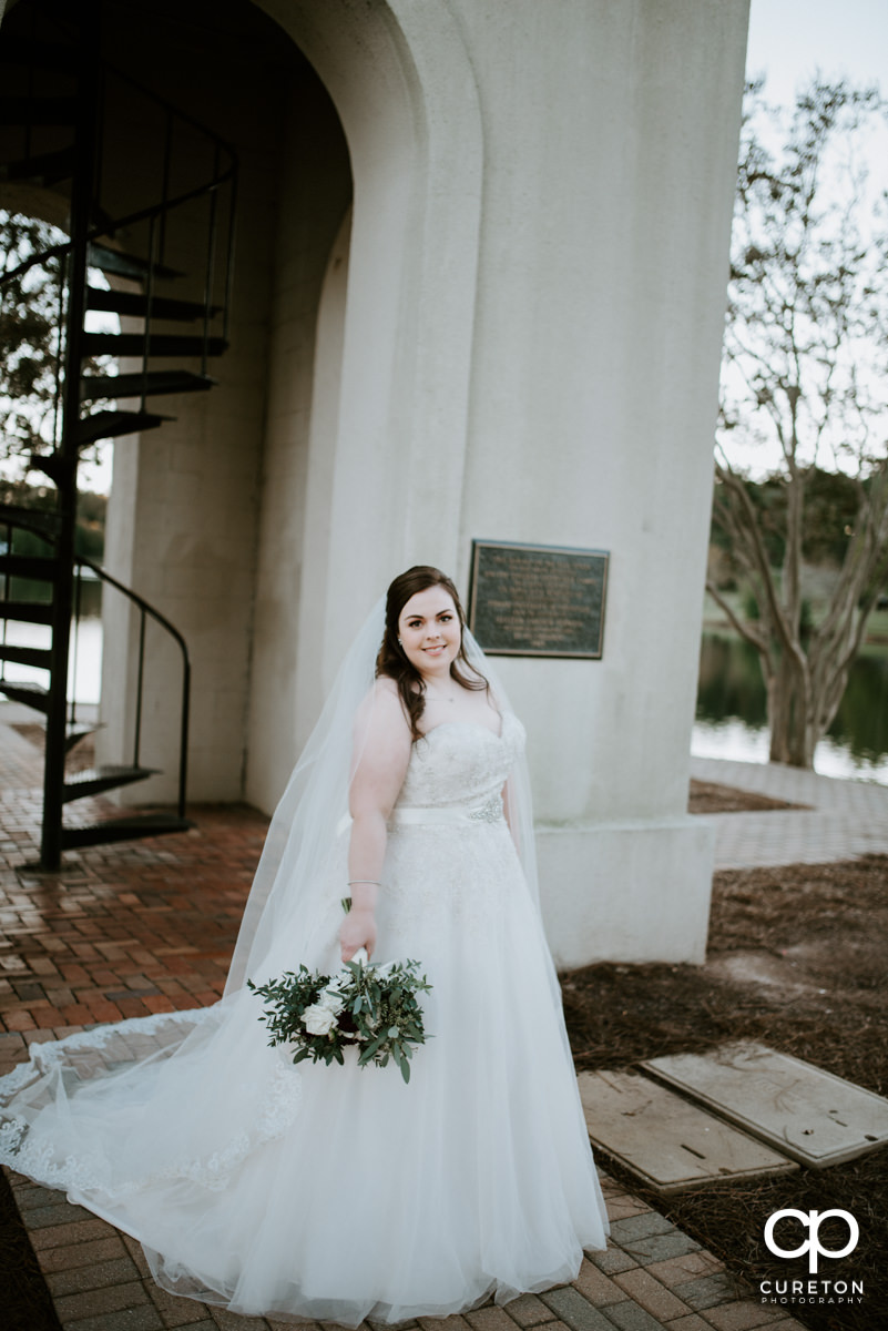 Bride holding her flowers out by the Bell Tower.