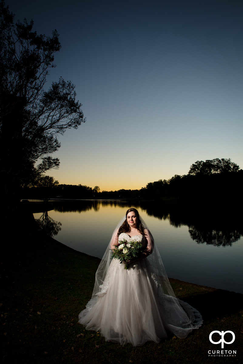 Bride by the lake at sunset.