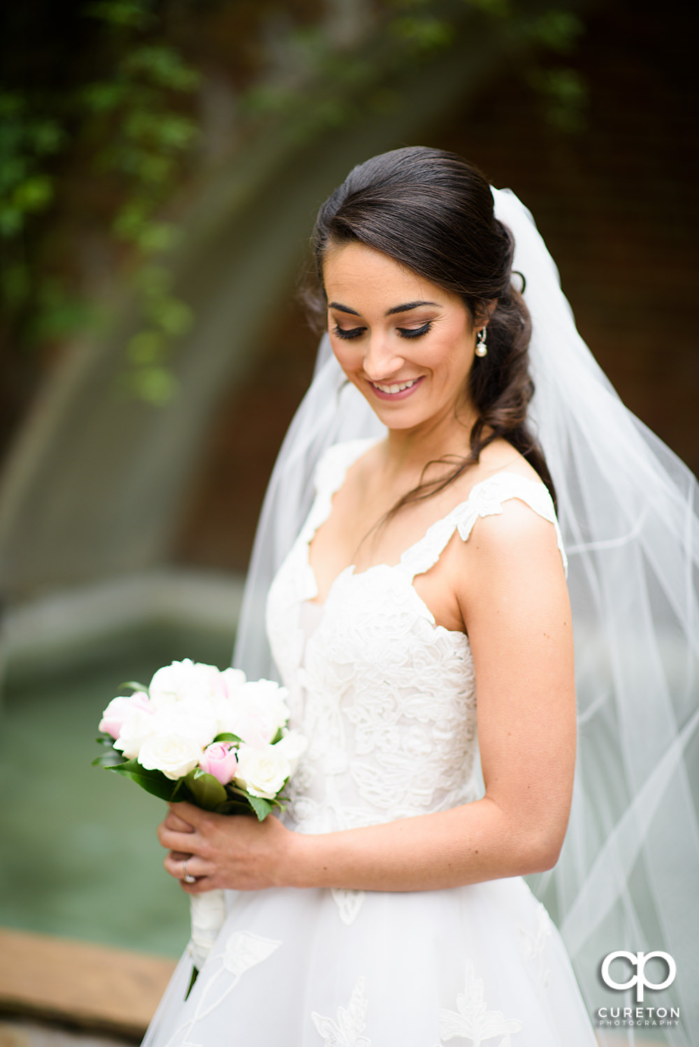 Bride smiling looking down her shoulder.