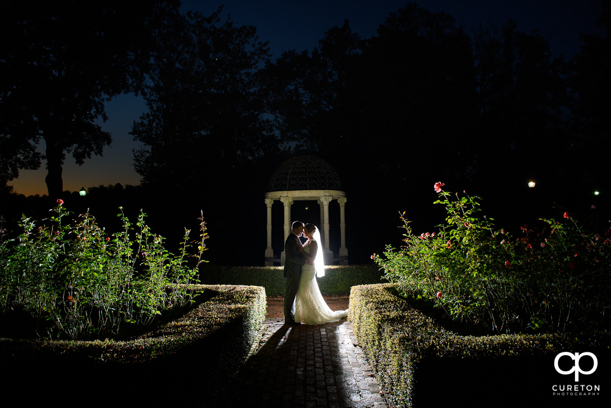 Bride and groom standing in the rose garden at Furman University after their intimate wedding ceremony.